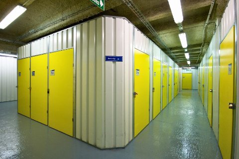 Couloir de boxes de stockage jaunes dans un centre Une Pièce en Plus à Paris
