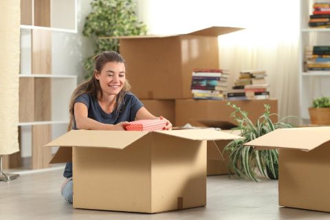 Étudiante emballant ses affaires dans un box – solution de stockage pratique pendant les vacances scolaires