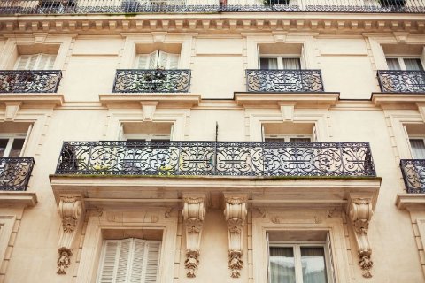 Façade d'un immeuble haussmannien à Paris avec balcons en fer forgé