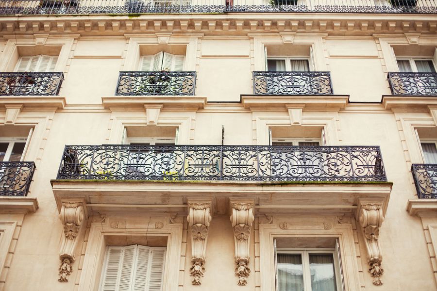 Façade d'un immeuble haussmannien à Paris avec balcons en fer forgé