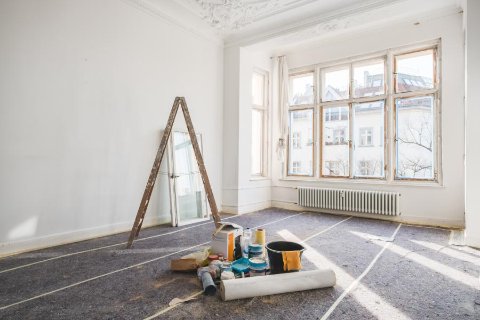 Pièce en cours de rénovation avec échelle et matériel de peinture – stockage temporaire pendant les travaux